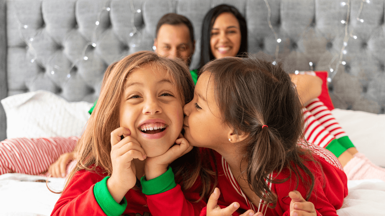 Jolly Jammies main home page banner. Photo shows family in matching Christmas pyjamas sitting on a bed.